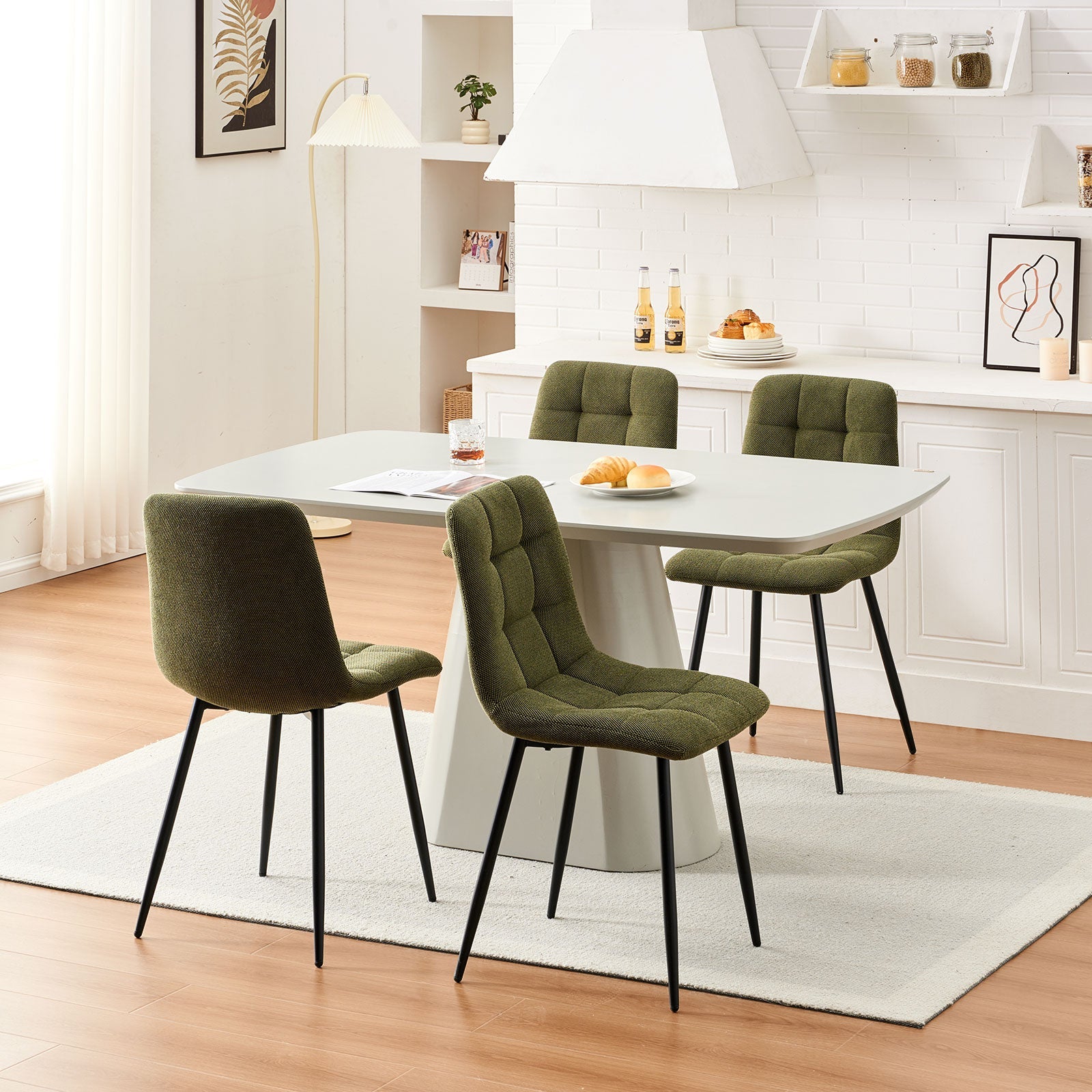 Set of four olive green Christie Fabric Dining Chairs styled around a four-seat dining table in a modern dining space.