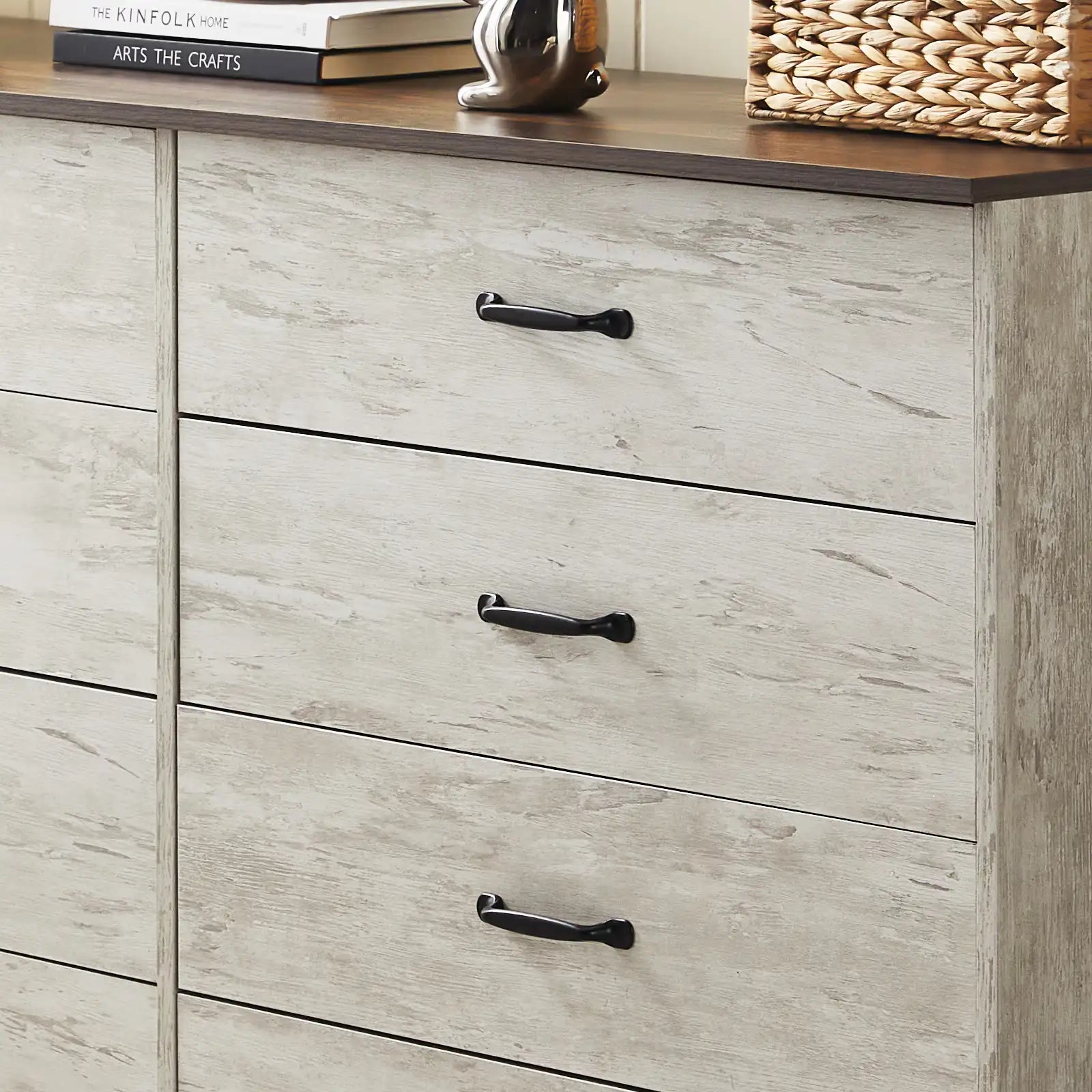 Details of Kamai rust brown chest of drawers, showing wood grain surface and black curved metal handles.