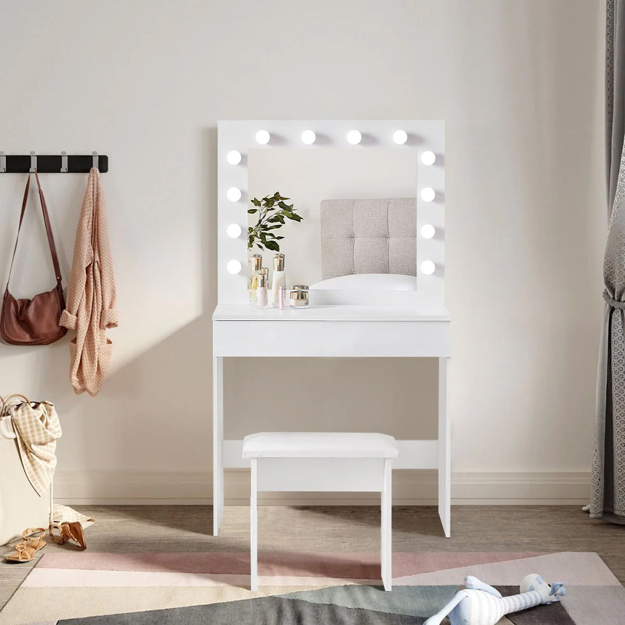 The front view of the white dressing table set, featuring a mirror, 12 LED bulbs, 1 drawer, and a stool, in a bright bedroom.