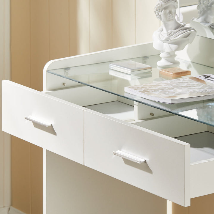 The closer view of the vanity's glass tabletop and 2 drawers under the tabletop, in a bright bedroom.