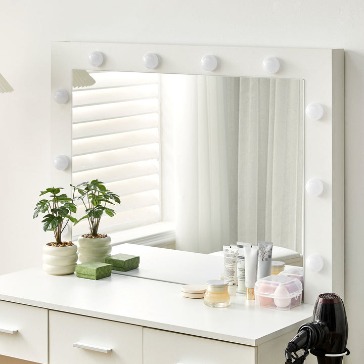 A closer look at the tabletop, mirror, and lights of the dressing  table