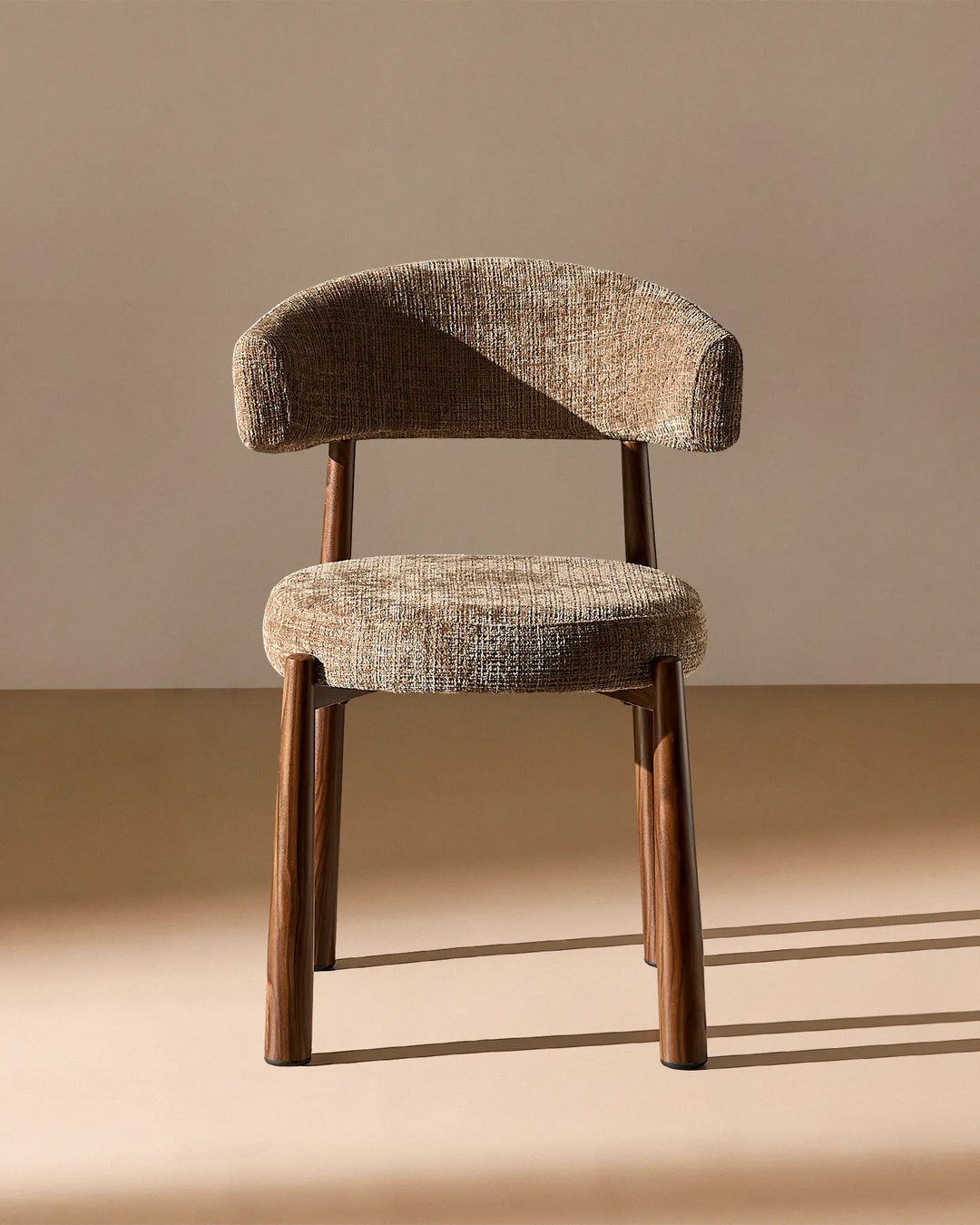Front view of the Ansel Mocha Chenille Dining Chair showing its curved upholstered backrest, rounded seat and slim wooden-effect legs.