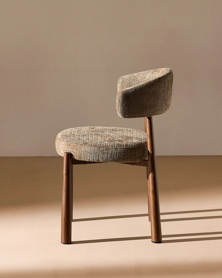 Side profile of the Ansel Mocha Chenille Dining Chair highlighting its curved backrest, upholstered seat and angled legs.