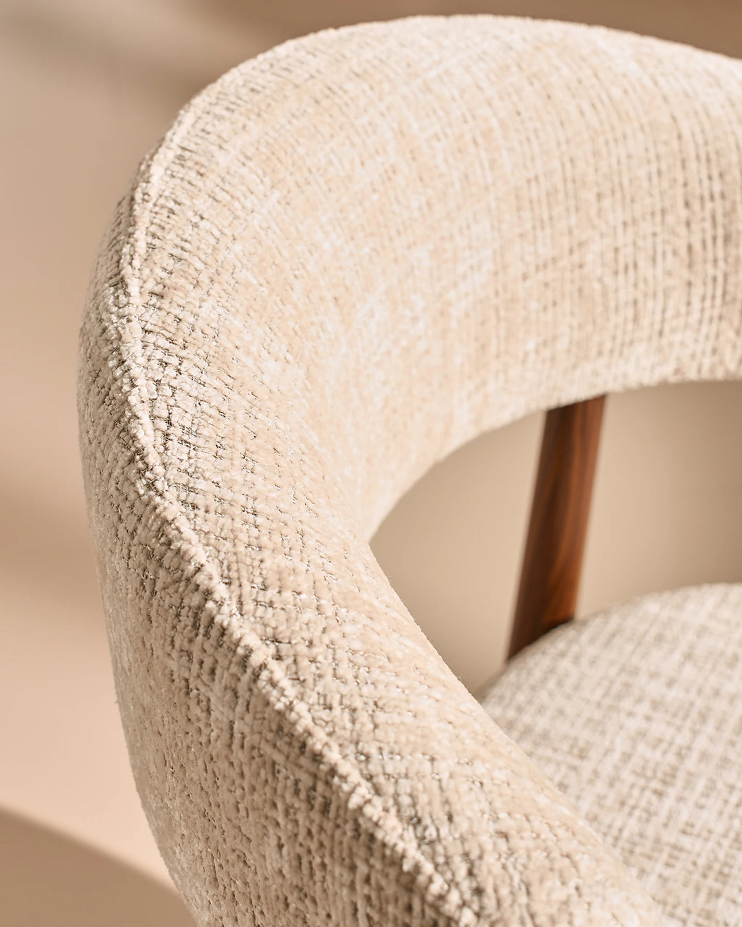 Close-up of the Ansel Oatmeal Chenille Dining Chair's curved backrest, showcasing the textured chenille upholstery and rounded edges.