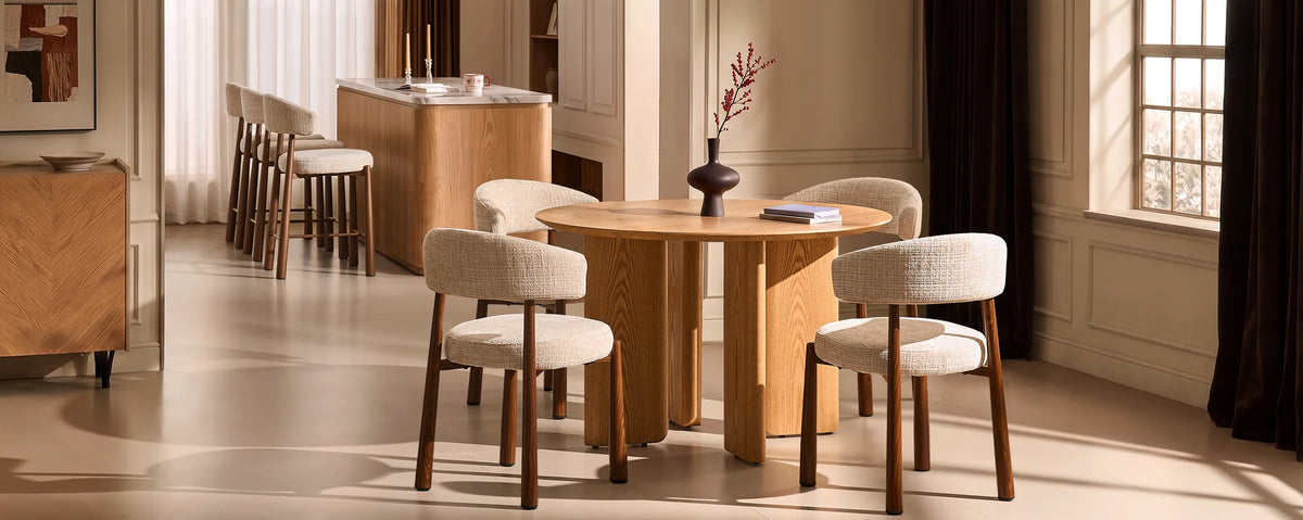 Ansel Oarmeal Chenille Dining Chairs around a round oak dining table in a bright, neutral dining room with coordinated wooden furniture.