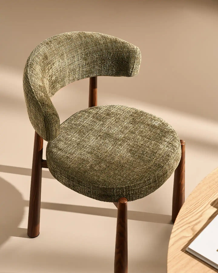 Angled view of the Ansel Olive Green Chenille Dining Chair showcasing its sculptural backrest, textured mocha chenille fabric and wooden-effect legs.