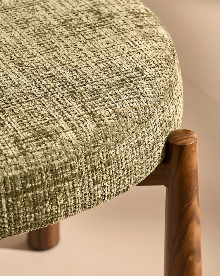 Close-up of the Ansel Olive Green Chenille Dining Chair showing the connection between the upholstered seat and its tapered wooden-effect leg.
