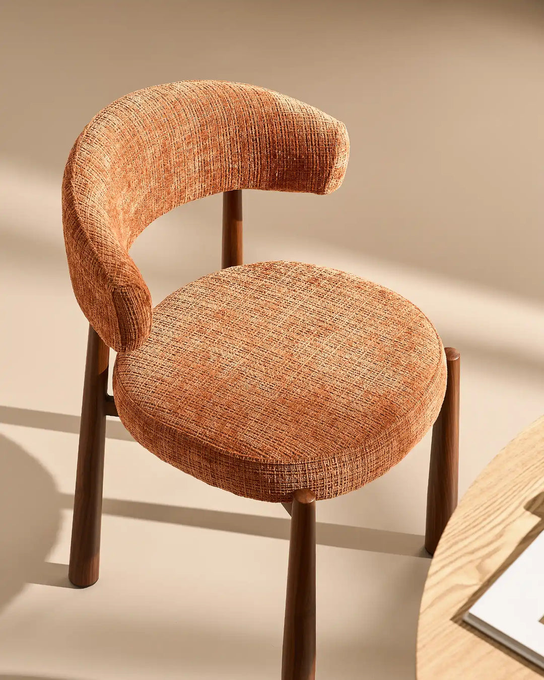 Angled view of the Ansel Terracotta Chenille Dining Chair showcasing its sculptural backrest, textured mocha chenille fabric and wooden-effect legs.