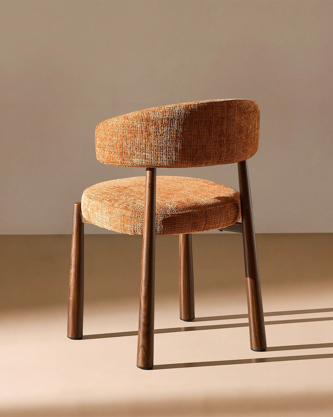 Rear view of the Ansel Terracotta Chenille Dining Chair showing the curved upholstered backrest and simple, elegant frame.