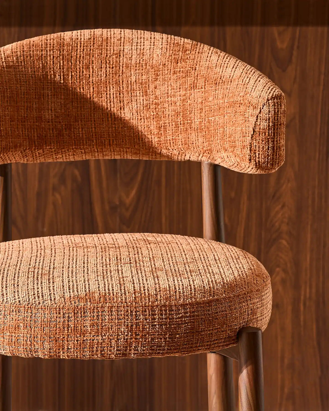 Detailed front close-up of the Ansel bar stool curved padded backrest upholstered in high-quality tactile terracotta orange chenille fabric