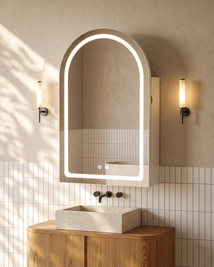 Arcadia white arched LED bathroom mirror cabinet with ambient halo lighting above a stone sink.