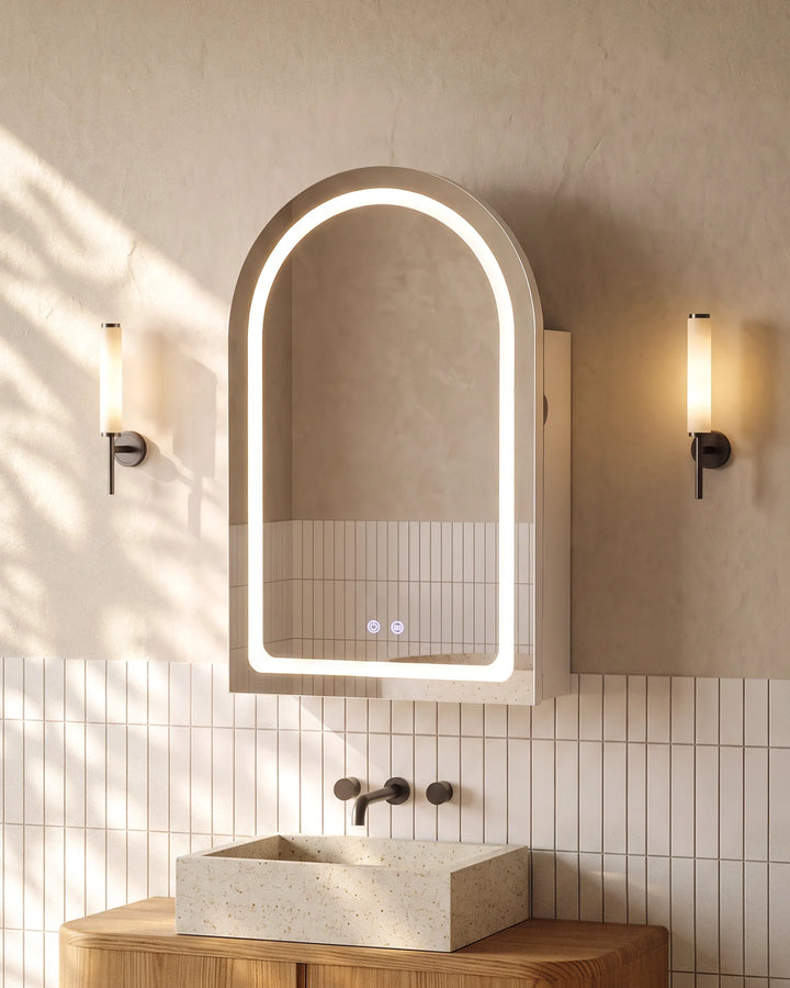 Arcadia white arched LED bathroom mirror cabinet with ambient halo lighting above a stone sink.