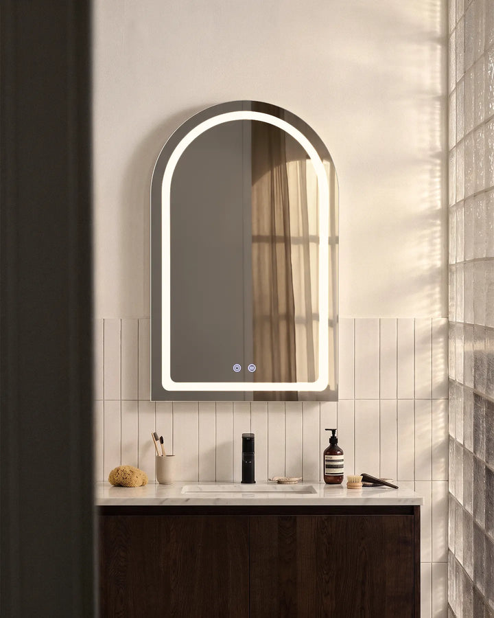 Arcadia white arched LED bathroom mirror installed above a dark wood vanity unit.