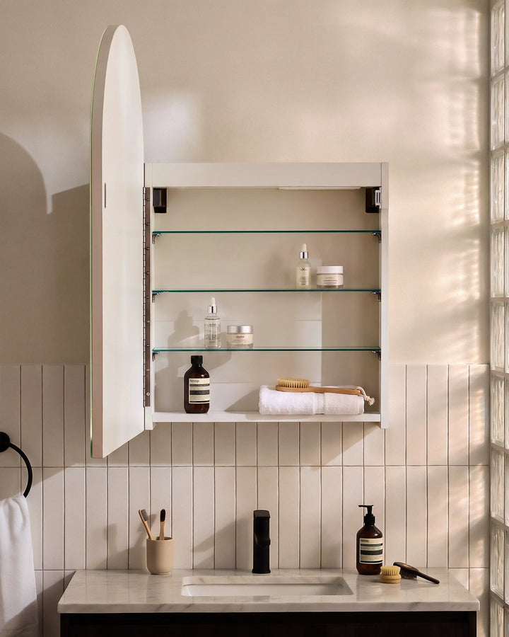 Interior view of Arcadia white arched cabinet showing three-tier adjustable glass shelving.