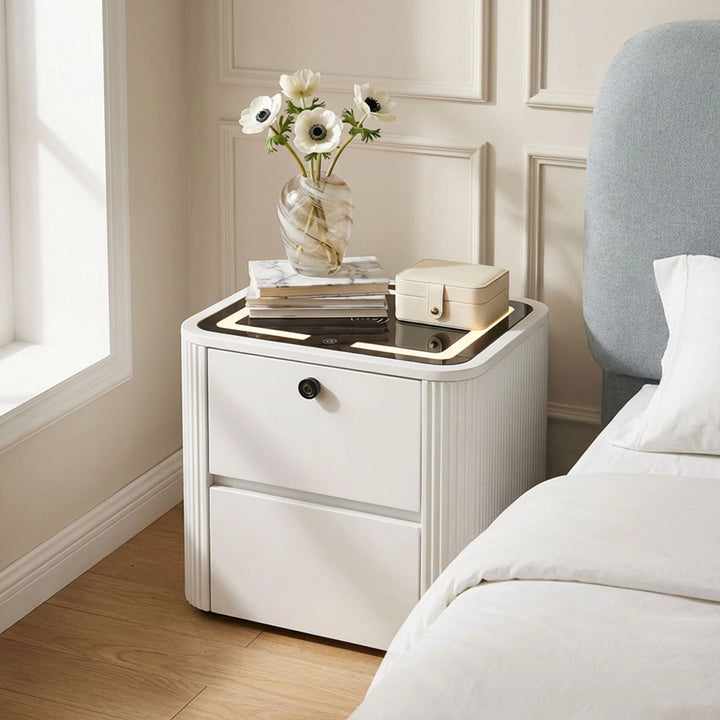 Side view of the Bexley smart bedside table beside a bed in a bright bedroom