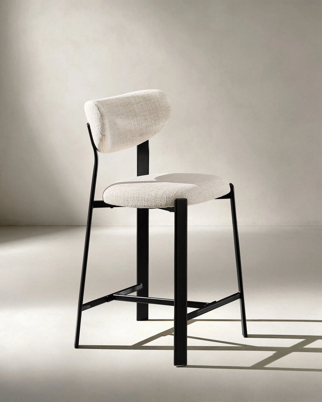Angled view of Bramley Black Oak Bar Stool with rustic linen upholstery and black oak wood effect legs