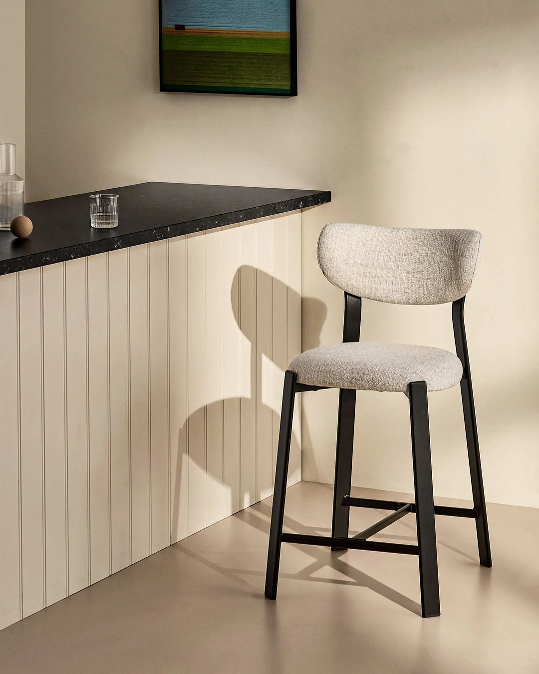 Bramley Black Oak Bar Stool beside a kitchen island with linen fabric upholstery and black oak wood effect legs