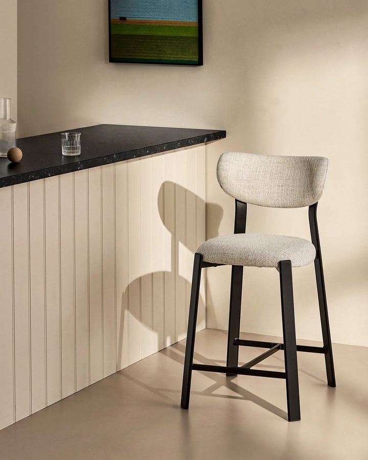 Bramley Black Oak Bar Stool beside a kitchen island with linen fabric upholstery and black oak wood effect legs