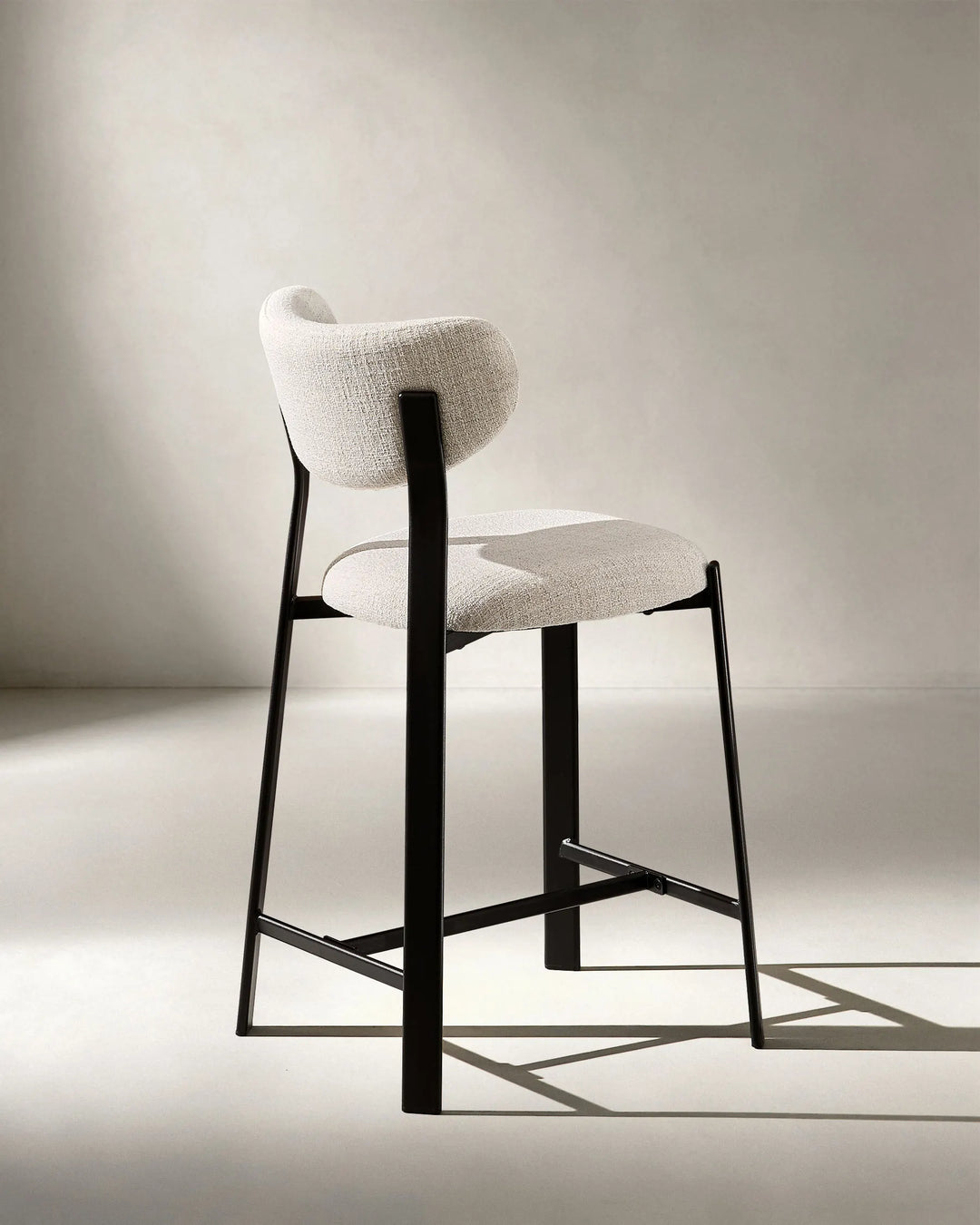 Rear view of Bramley Black Oak Bar Stool highlighting curved back and wood effect frame