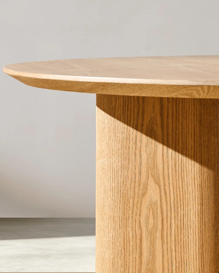 Bramley dining table detail showing the thick tabletop profile and oak-effect wooden leg texture