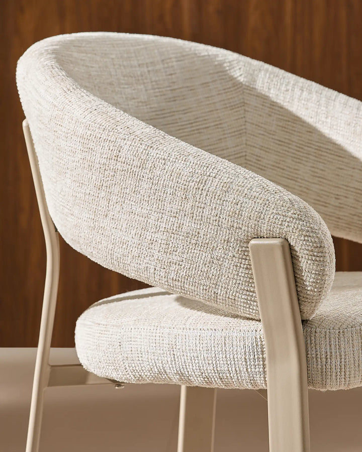Side view of Bramley ivory and off white dining chair displaying curved arms, supportive backrest and wood legs