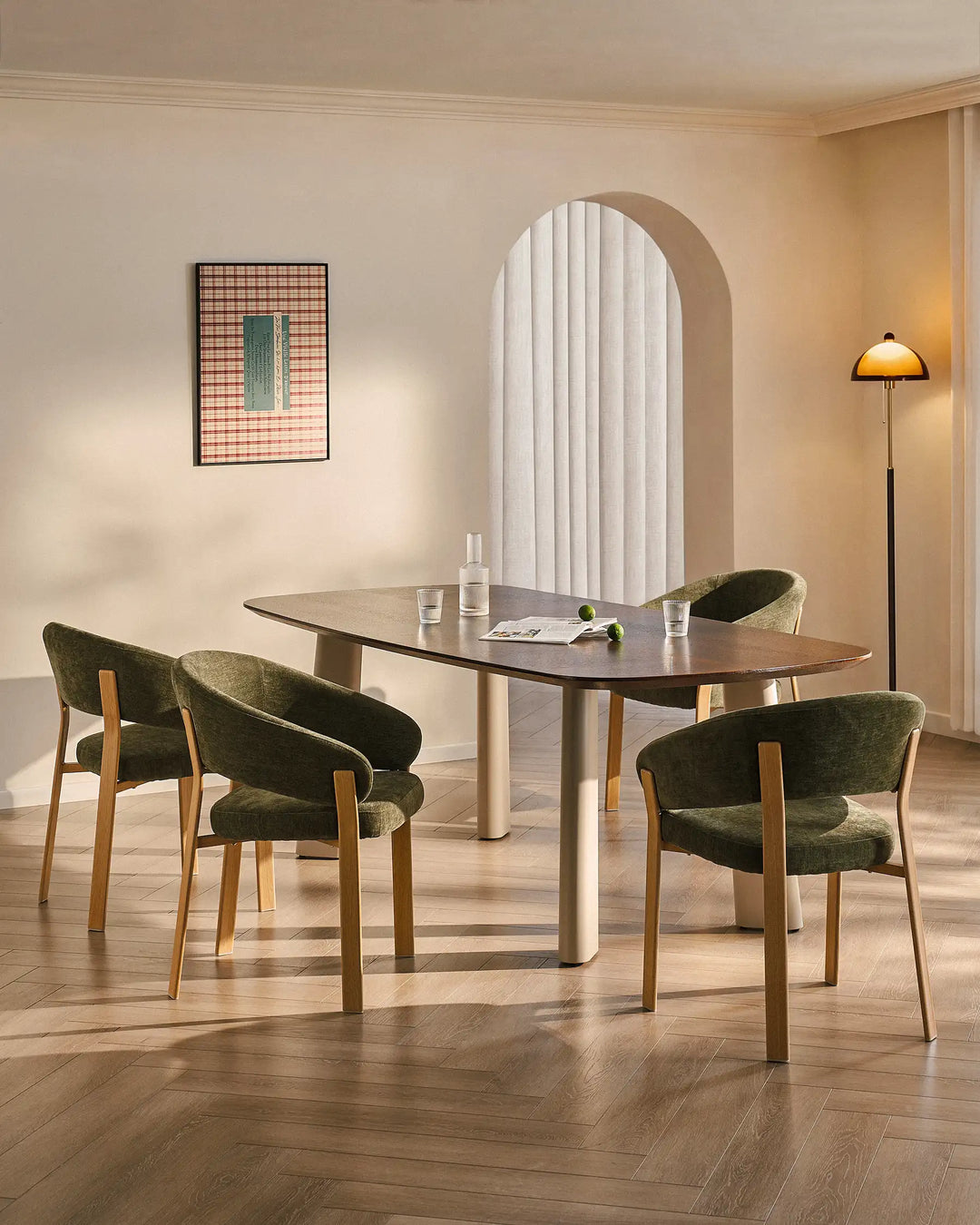 Four Bramley moss green and oak dining armchairs surrounding a dining table in a warm organic dining space