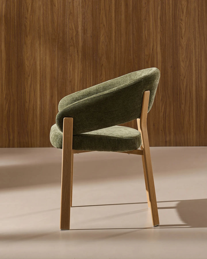 Side view of Bramley moss green and oak rustic dining chair showing curved silhouette and armrests
