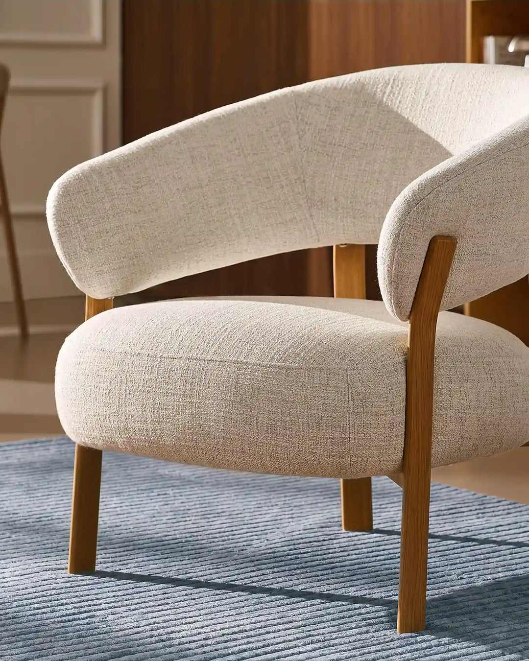 Rear view of the Bramley Accent Chair with oak wood legs and curved backrest