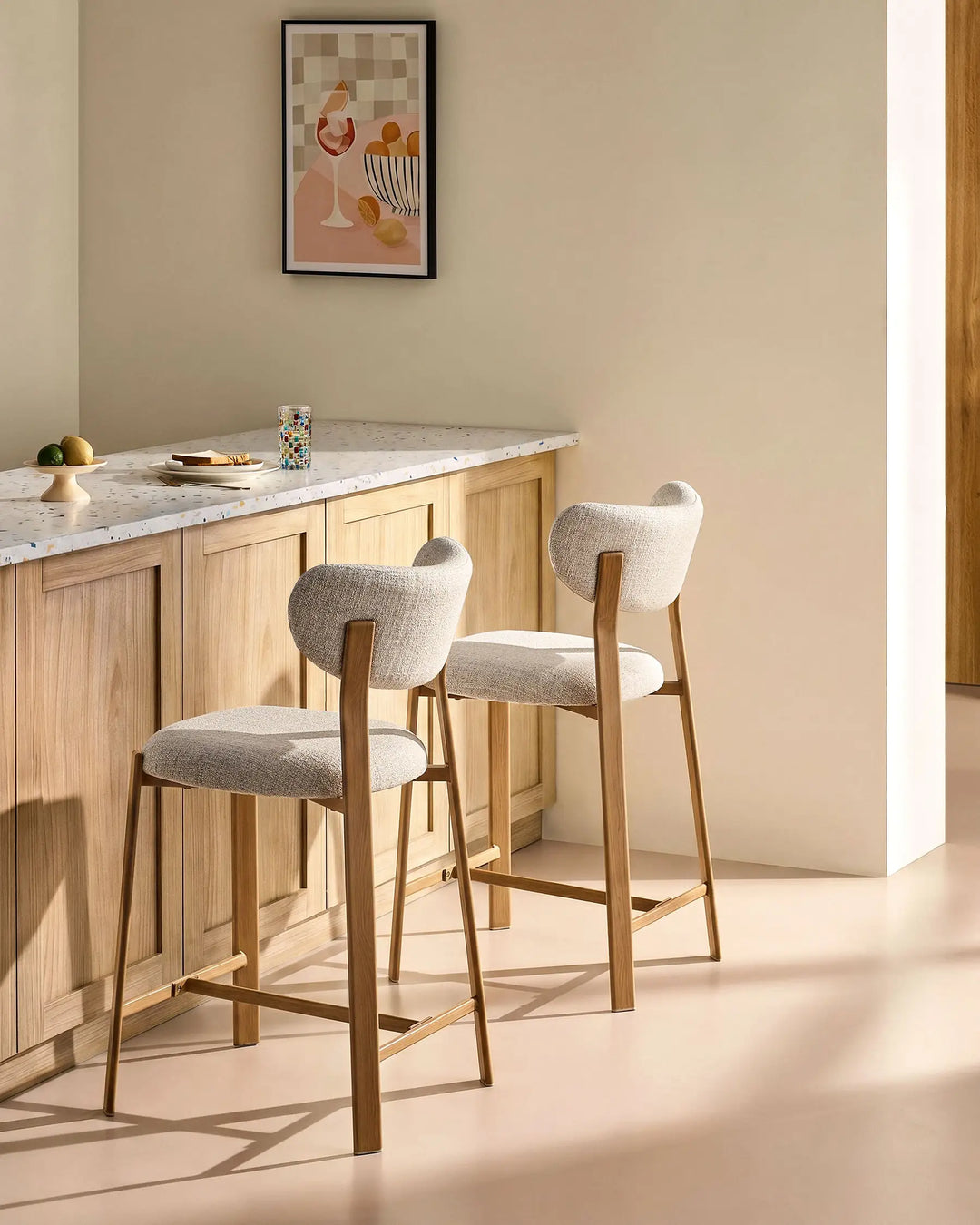 Side view of two Bramley Oak Bar Stools by a kitchen island, rustic bar seating with linen fabric and wood effect legs