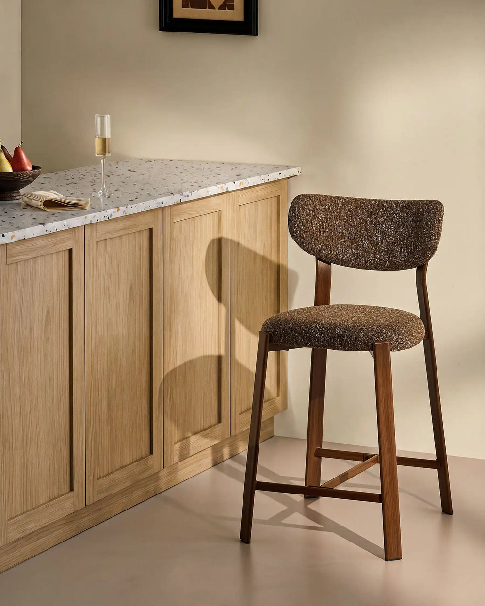 Bramley Walnut Bar Stool beside a kitchen island with linen fabric upholstery and walnut wood effect legs