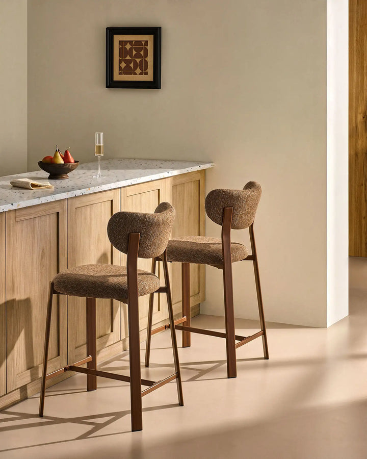Side view of two Bramley Walnut Bar Stools by a kitchen island, modern rustic seating with wood effect legs