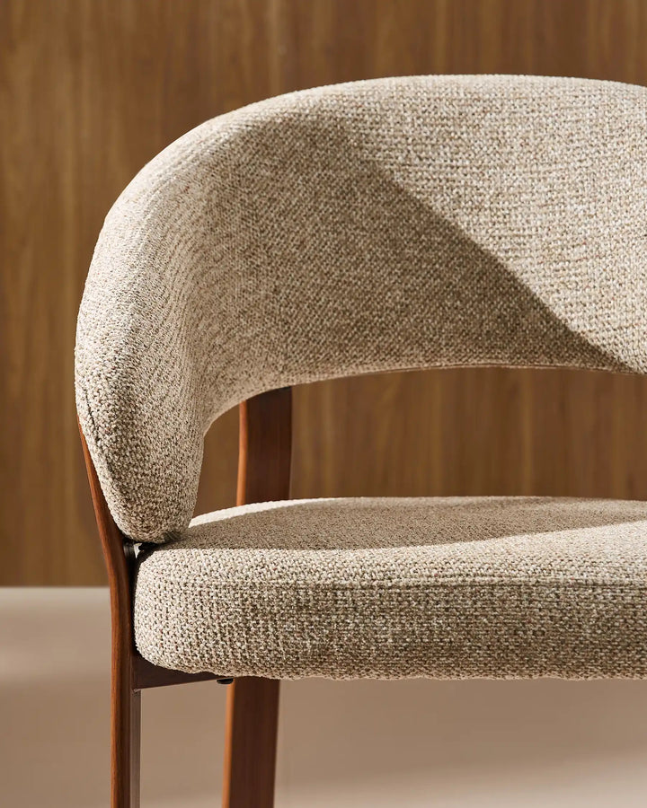 Front view of Bramley warm taupe and walnut dining armchair showing curved armrests and upholstered seat details