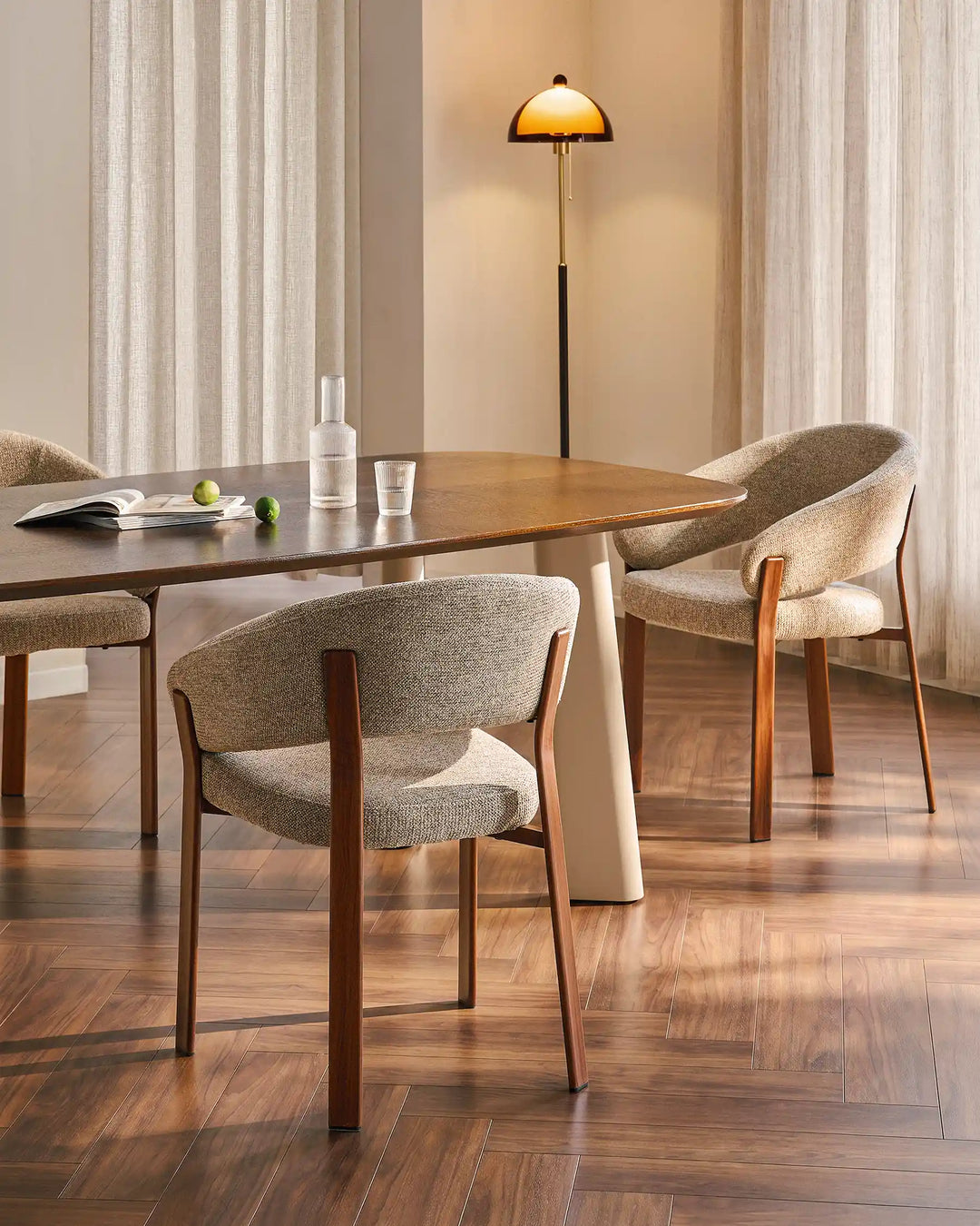 Two Bramley warm taupe and walnut dining armchairs placed at a dining table in an organic farmhouse dining room
