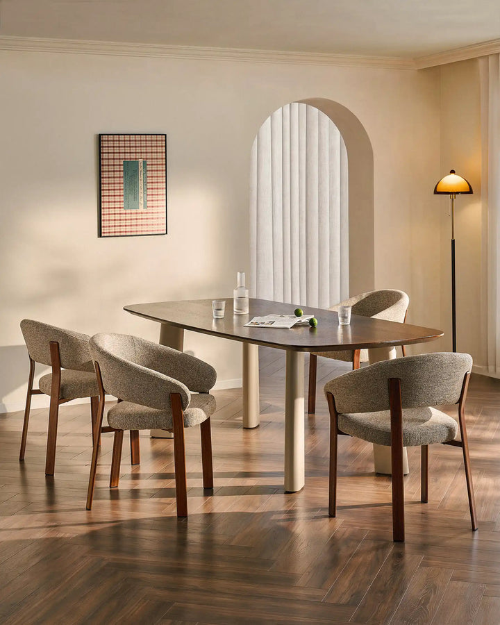 Four Bramley warm taupe and walnut dining armchairs surrounding a dining table in a warm organic dining space