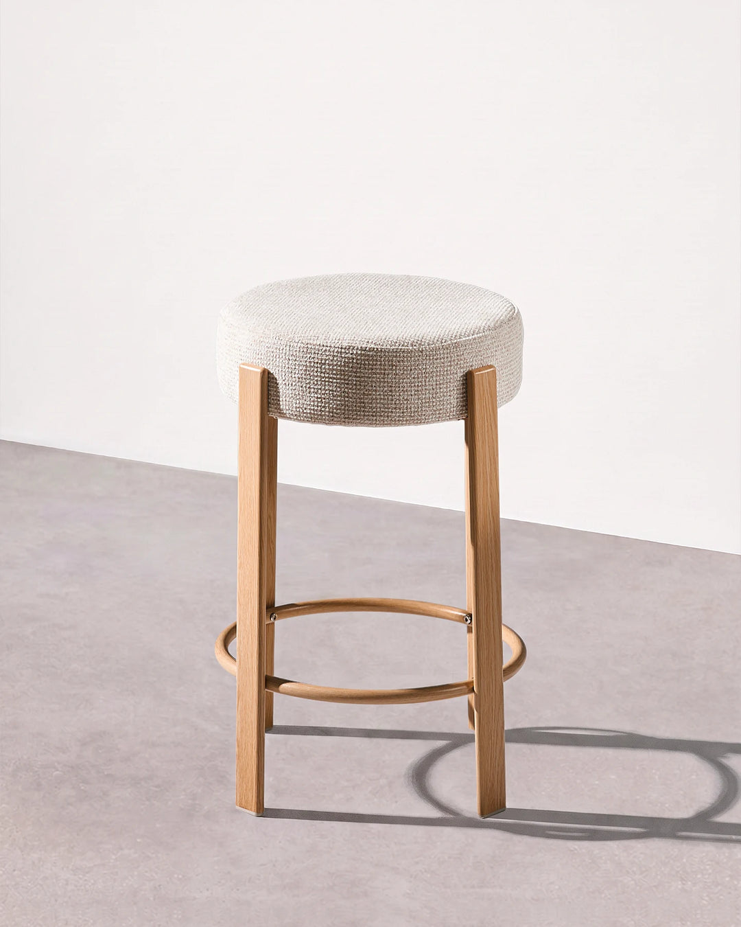 Full view of a Bramley cream chenille backless bar stool against a neutral background, showing the cream upholstered seat, veneer frame and circular footrest