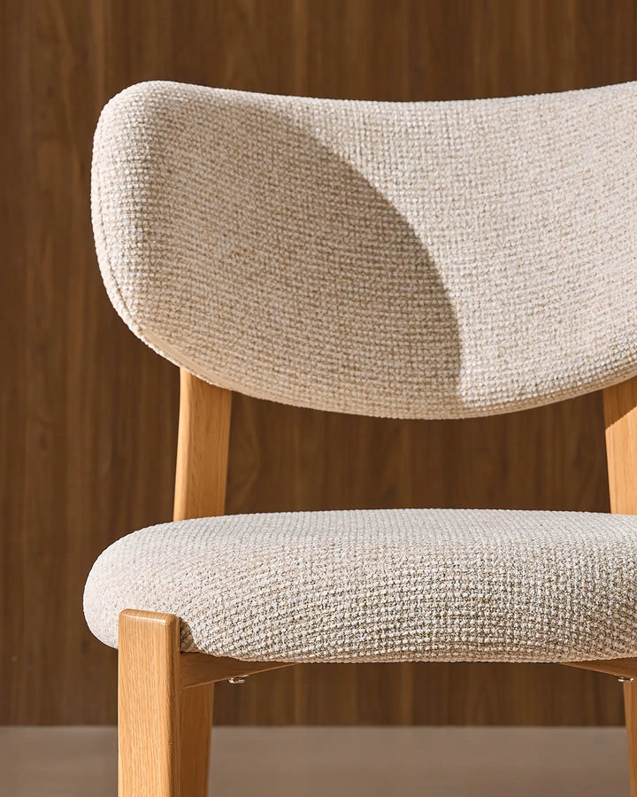 Close-up of the curved cream chenille backrest and upholstered seat of the Bramley dining chair