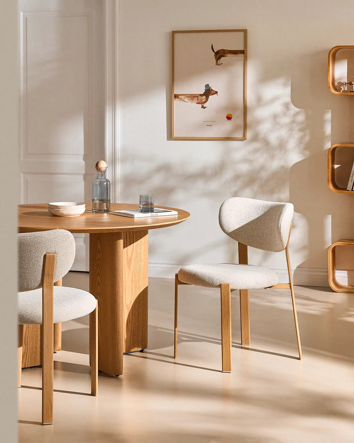Bramley cream chenille dining chairs arranged around a wooden dining table in a bright, neutral dining room
