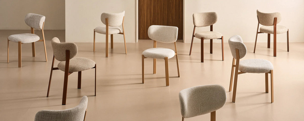 A selection of Bramley dining chairs with warm wood-effect legs in a neutral interior