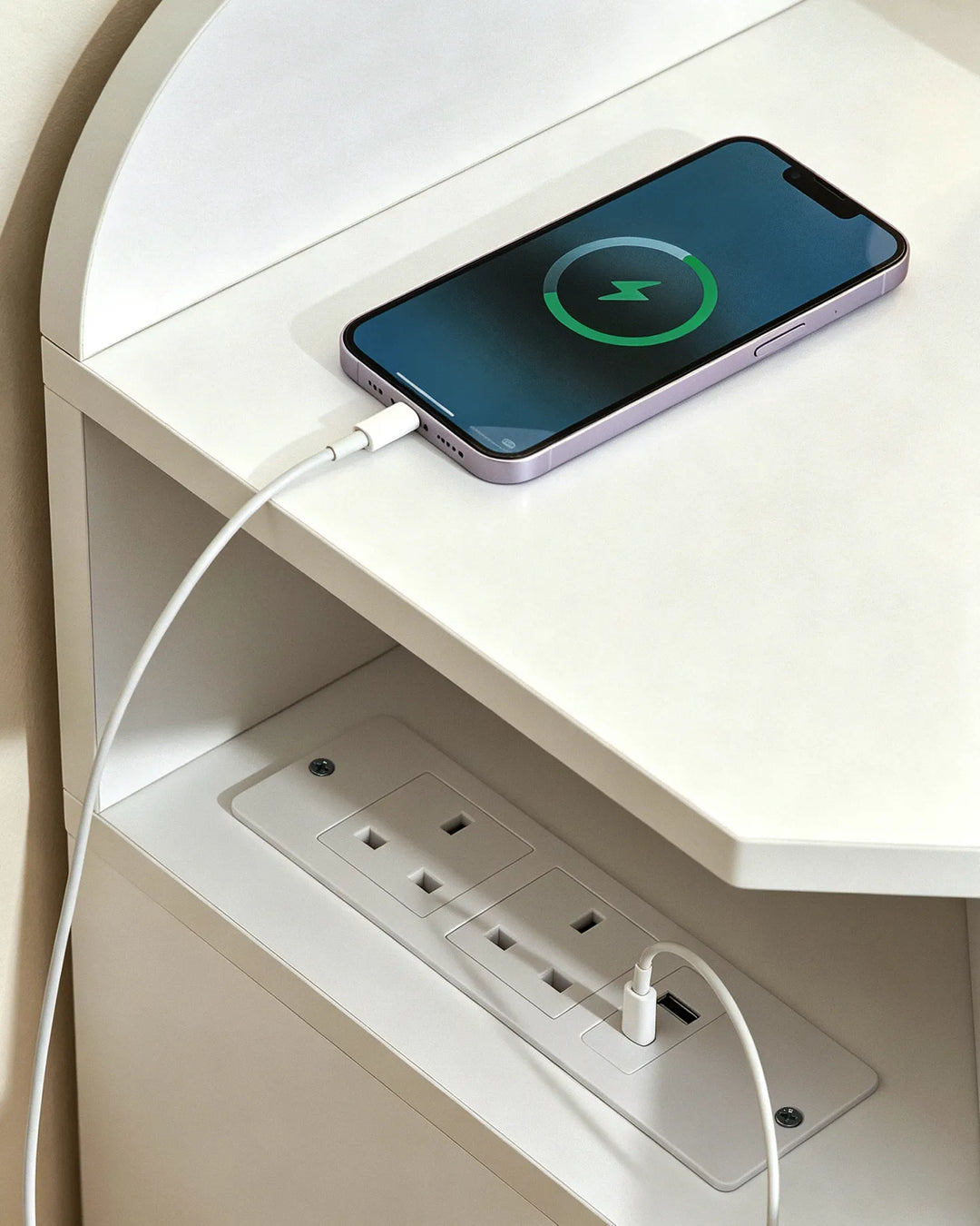 Close-up of the integrated power outlets on a white corner dressing table