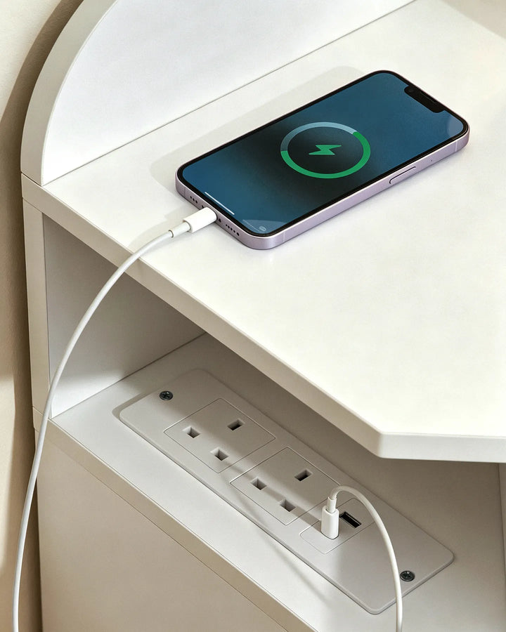 Close-up of the integrated power outlets on a white corner dressing table