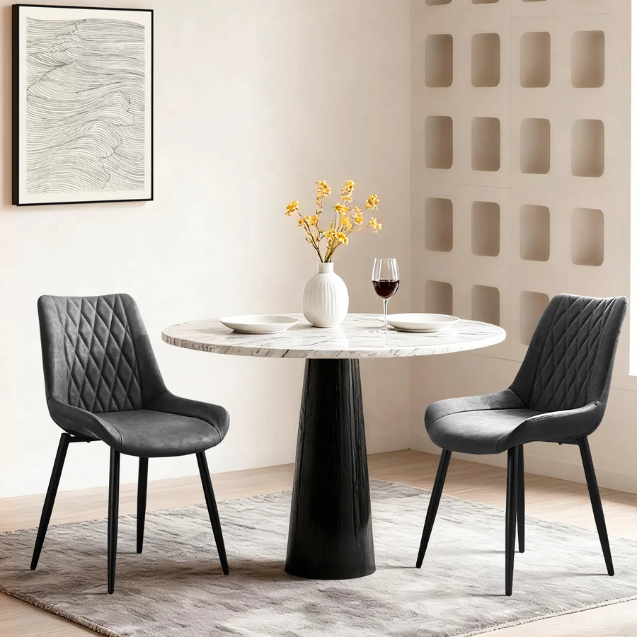 Carl Dining Chair - displaying a set of 2 grey dining chairs for a round dining table on a grey carpet, there are plates and a vase on the table; and a wall picture on the white wall.