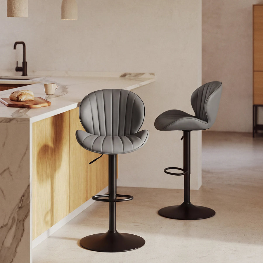 2 bar stools with shell back and ajustable height, beside a kitchen island