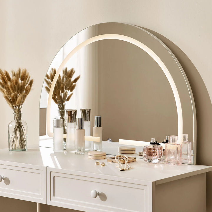Close-up of Ceris vanity curved mirror with warm LED lighting.