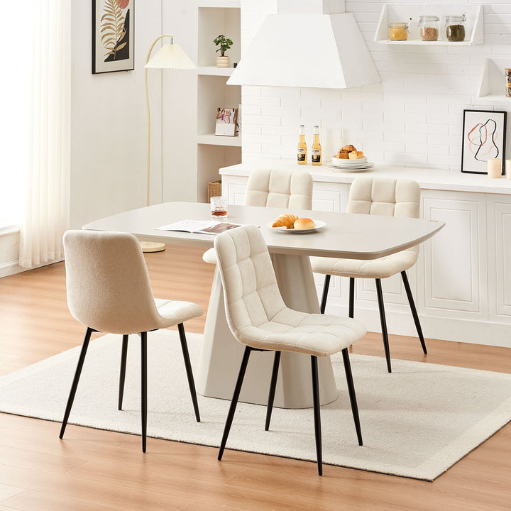 Set of 4 cream Christie Fabric Dining Chairs styled around a four-seat dining table in a modern dining space.