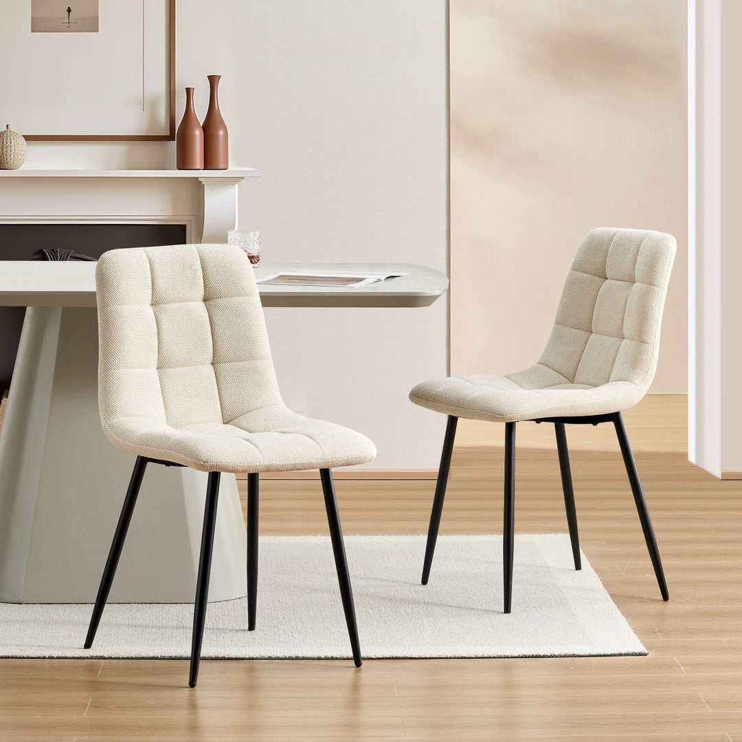 Cream Christie Fabric Dining Chairs placed opposite each other at a dining table