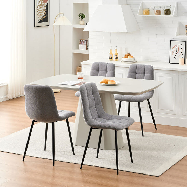 Set of 4 grey Christie Fabric Dining Chairs styled around a four-seat dining table in a modern dining space.