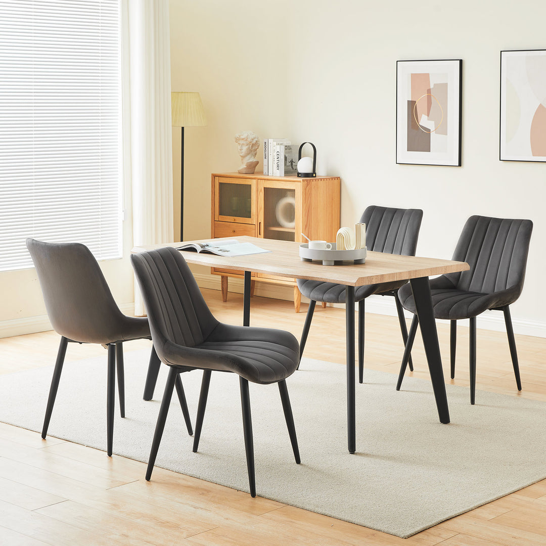 Set of 4 grey velvet dining chairs around a dining table in a modern dining room