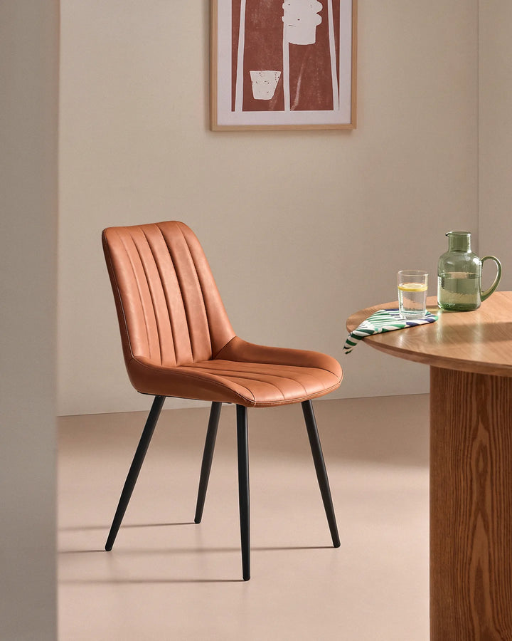 Clair tan brown faux leather upholstered dining chair placed in an elegant neutral dining space, perfect for modern kitchen and dining room interiors.