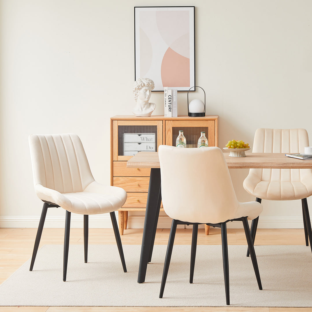 3 cream white velvet dining chairs around a dining table in a modern dining room, showing different angles of the chairs.