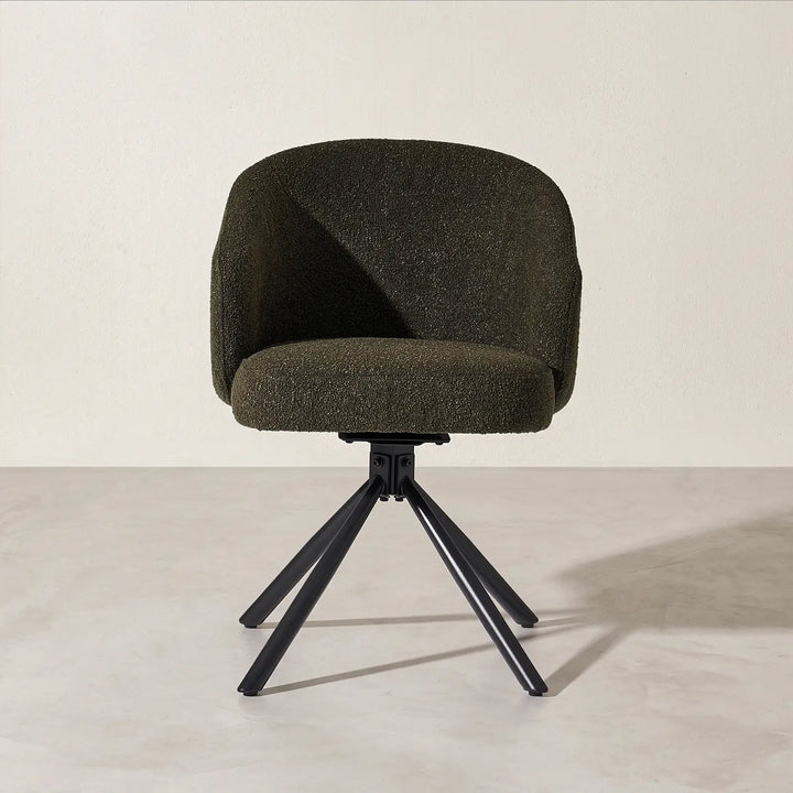 Front studio view of the Cleo green bouclé swivel chair, showcasing the supportive padded seat cushion and splayed four-star black metal swivel base.